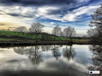 Water Like Frosted Glass  This is a view I have shot often. In summer, it can pass without notice, but from late autumn to spring, this curve in the River, not far upstream of Teston Lock, can give immaculate reflections, as well as huge unobstructed skies. This photo was made from eight iPhone6 frames stitched together using PTGui computer software. The gap of a second or so between each frame meant the River had moved on slightly every time the shutter was pressed. The result is unpredictable and unique to the moment.	£200